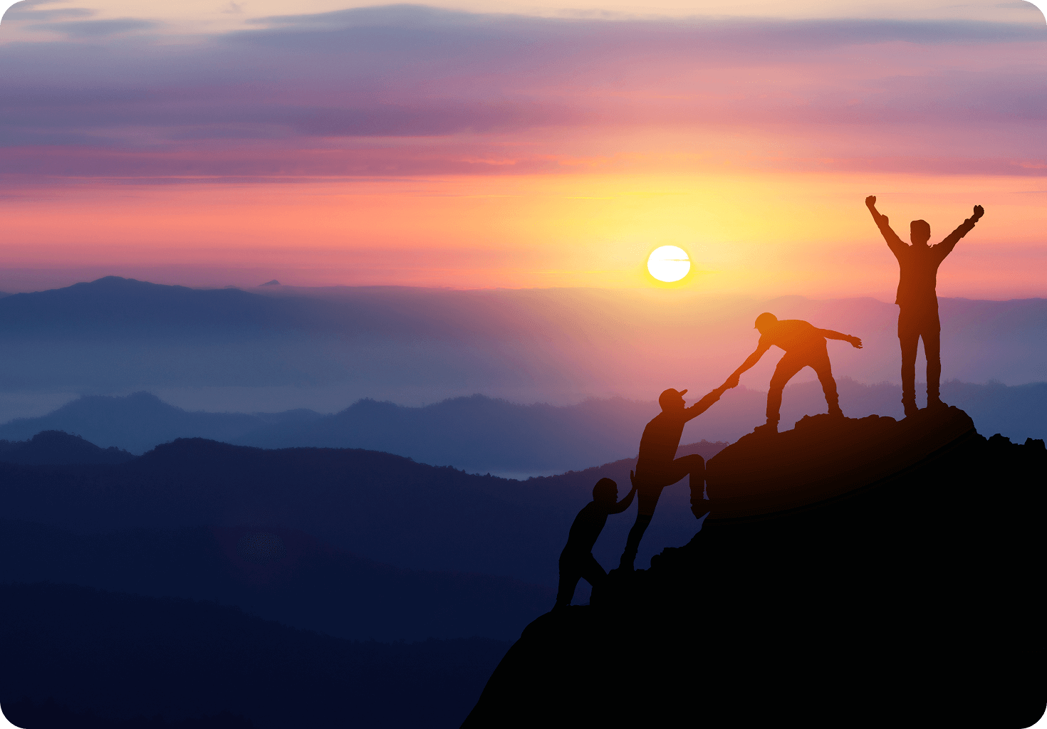 GettyImages-1366352000 (5) (1) Silhouetted figures help each other climb a mountain at sunrise, with a person raising arms triumphantly at the peak.